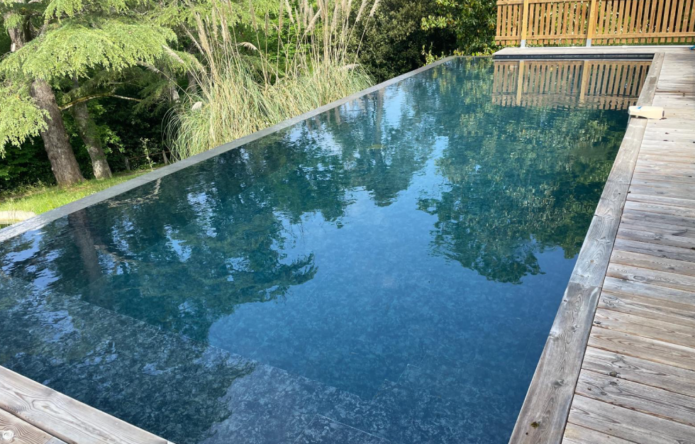 Projet sur mesure de piscine débordement Carcans avec terrasse moderne, signée Couleur piscine du sud ouest